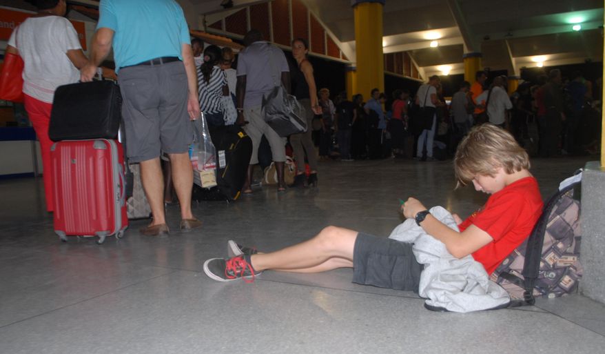 A child rests as passengers go through security screening at Moi International Airport Mombasa Kenya, Sunday, Dec. 20, 2015 after their earlier flight was involved in a bomb scare and they were evacuated to different hotels in Mombasa. (AP Photo)
