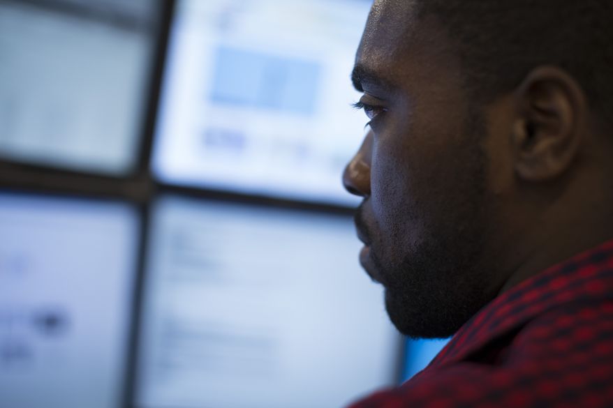 In this Wednesday, May 20, 2015 photo, Eric Dinkins, cyber security analyst associate, works at a computer station in the Cyber Security Operations Center at AEP headquarters in Columbus, Ohio. (AP Photo/John Minchillo)