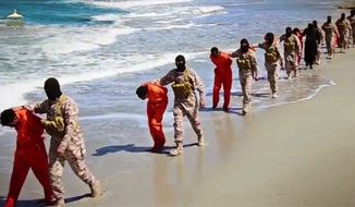 FILE - EDS NOTE: GRAPHIC CONTENT - This image made from video posted online April 19, 2015 by supporters of the Islamic State militant group on an anonymous photo sharing website, members of an IS affiliate walk captured Ethiopian Christians along a beach in Libya. The video purportedly shows two groups of captives: one held by an IS affiliate in eastern Libya and the other by an affiliate in the south. A masked militant delivers a long statement before the video switches between footage that purportedly shows the captives in the south being shot dead and the captives in the east being beheaded on a beach. (Militant video via AP, File)