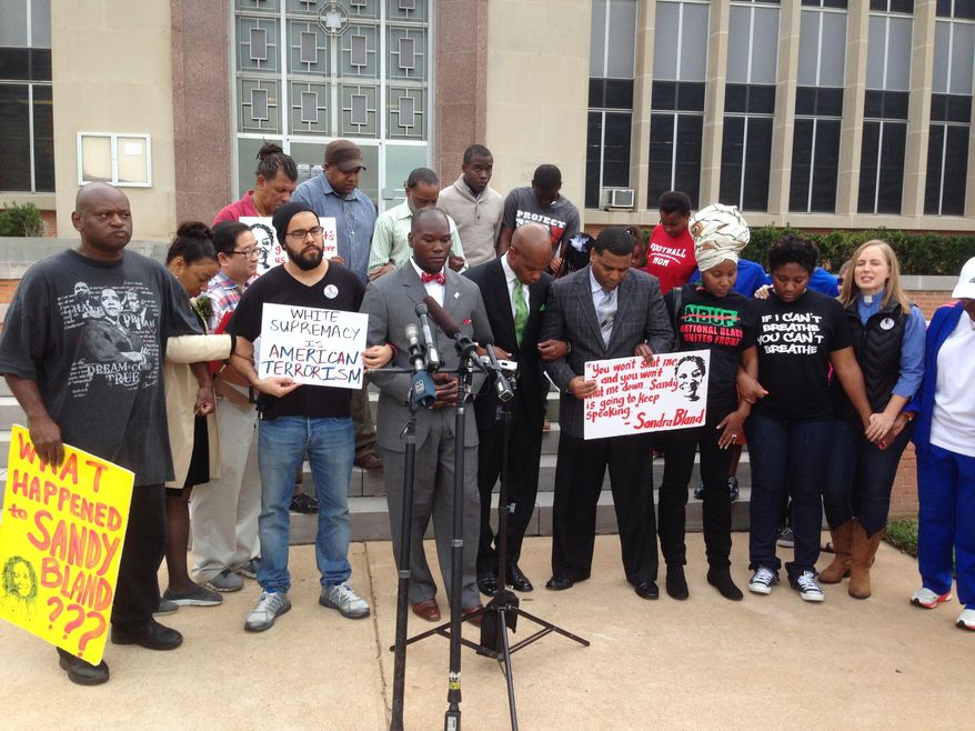 People gather for a protest Tuesday, Dec. 22, 2015, outside the Waller County courthouse in Hempstead, Texas, after a grand jury on Monday decided that no felony crime was committed by sheriff's officers or jailers in the death of Sandra Bland. Authorities say Bland hanged herself in jail with a plastic garbage bag three days after trooper Brian Encinia pulled her over for not signaling a lane change. (AP Photo/Michael Graczyk)