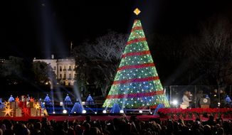 President Barack Obama and the first family stands, right, after lighting the 2014 National Christmas Tree during the National Christmas Tree lighting ceremony at the Ellipse near the White House in Washington, Thursday, Dec. 4, 2014. (AP Photo/Carolyn Kaster)