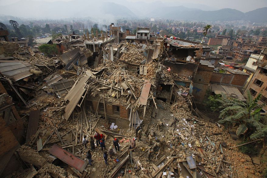 Rescue workers remove debris as they search for victims of earthquake in Bhaktapur near Kathmandu, Nepal, Sunday, April 26, 2015. A strong earthquake shook Nepal&#x27;s capital and the densely populated Kathmandu Valley before noon, causing extensive damage with toppled walls and collapsed buildings. (AP Photo/Niranjan Shrestha, File)