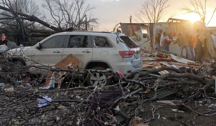 Neighbors help salvage items from a storm-damaged home in the Roundaway community near Clarksdale, Miss., on Wednesday. A storm system forecasters called "particularly dangerous" killed multiple people as it swept across the country Wednesday. (The Press Register via Associated Press)