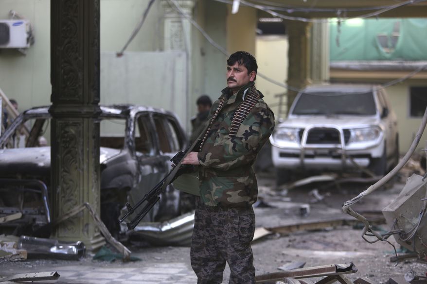 An Afghan security forces member stands guard at the Spanish Embassy after an attack in Kabul on Dec. 12. Explosions and gunfire rocked a diplomatic area of central Kabul overnight as security forces tried to flush out Taliban attackers who claimed responsibility for a deadly car bomb Friday. (Associated Press)