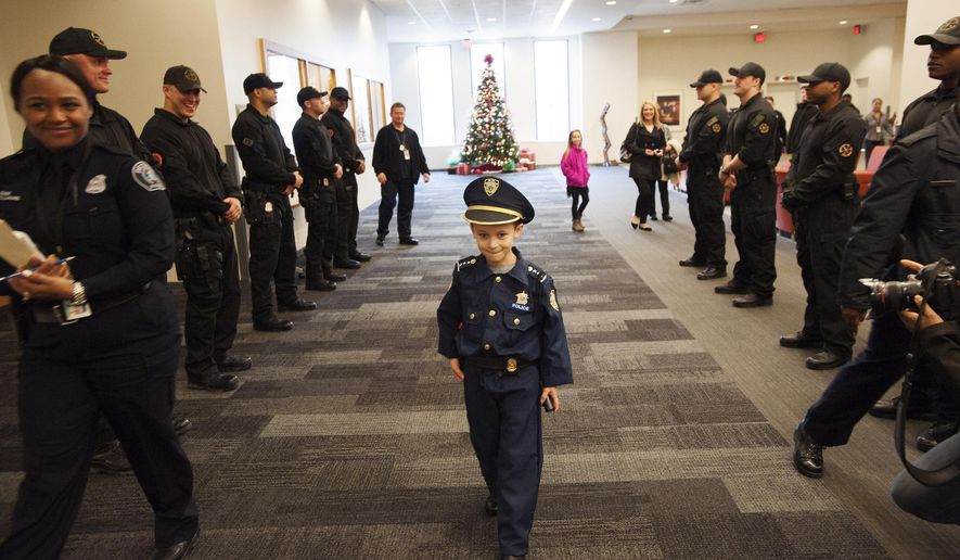 Detroit Police "Chief for a Day" Carter Widmer, 7, arrives at the Detroit Public Safety Headquarters on Wednesday, Dec. 23, 2015, in Detroit. Widmer donated $250 of his Christmas money to the Detroit Police K-9 Unit. (John T. Greilick/Detroit News via AP) DETROIT FREE PRESS OUT; HUFFINGTON POST OUT; MANDATORY CREDIT