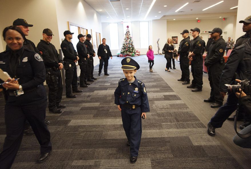 Detroit Police "Chief for a Day" Carter Widmer, 7, arrives at the Detroit Public Safety Headquarters on Wednesday, Dec. 23, 2015, in Detroit. Widmer donated $250 of his Christmas money to the Detroit Police K-9 Unit. (John T. Greilick/Detroit News via AP) DETROIT FREE PRESS OUT; HUFFINGTON POST OUT; MANDATORY CREDIT