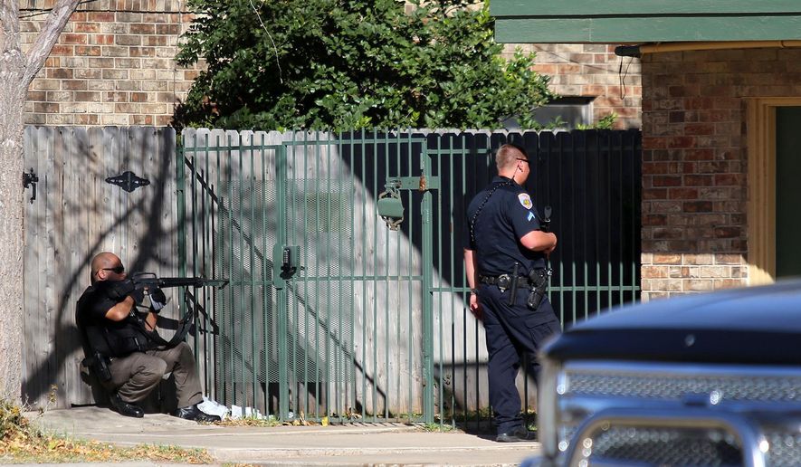 Officers wait outside an apartment complex on Wednesday Dec. 23, 2015, in Odessa, Texas. Authorities say multiple Odessa police officers have been shot while attempting to serve a warrant at the apartment complex, with the suspect barricaded inside. (Edyta Blaszczyk/Odessa American via AP) MANDATORY CREDIT