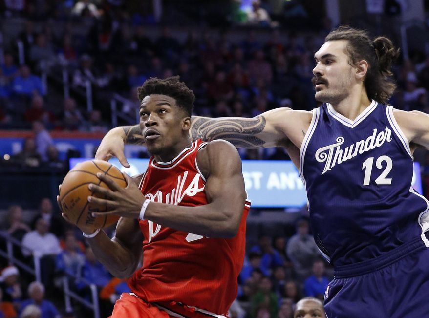 Chicago Bulls guard Jimmy Butler, left, goes to the basket ahead of Oklahoma City Thunder center Steven Adams (12) during the third quarter of an NBA basketball game in Oklahoma City, Friday, Dec. 25, 2015. Chicago won 105-96. (AP Photo/Alonzo Adams)
