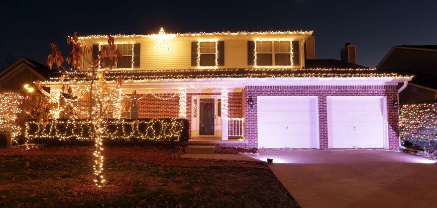 This photo taken on Dec. 15, 2015, shows the Wyndham Downs neighborhood home of Ryan and Kayla Jones with Christmas lights synchronized with Trans-Siberian Orchestra music which is broadcast on a low power FM frequency, in Lexington, Ky. (Pablo Alcala /Lexington Herald-Leader via AP) MANDATORY CREDIT