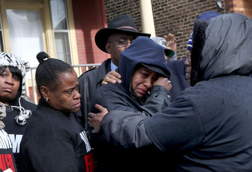 Janet Cooksey, center, the mother of Quintonio LeGrier, is comforted by family and friends during a news conference to speak out about Saturday's shooting death of her son by the Chicago police, on Sunday, Dec. 27, 2015, in Chicago. Grieving relatives and friends of two people shot and killed by Chicago police said Sunday that the city's law enforcement officers had failed its residents. (Nancy Stone/Chicago Tribune via AP) MANDATORY CREDIT