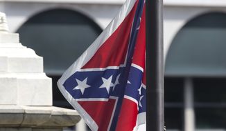An honor guard from the South Carolina Highway patrol removes the Confederate battle flag from the Capitol grounds in Columbia, S.C., on July 10, 2015, ending its 54-year presence there. (Associated Press) **FILE**