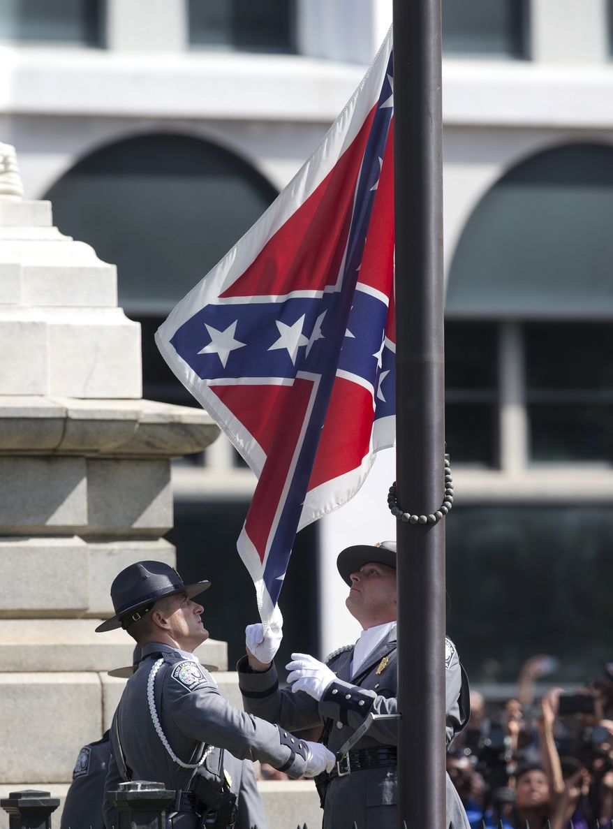 An honor guard from the South Carolina Highway patrol removes the Confederate battle flag from the Capitol grounds in Columbia, S.C., on July 10, 2015, ending its 54-year presence there. (Associated Press) **FILE**