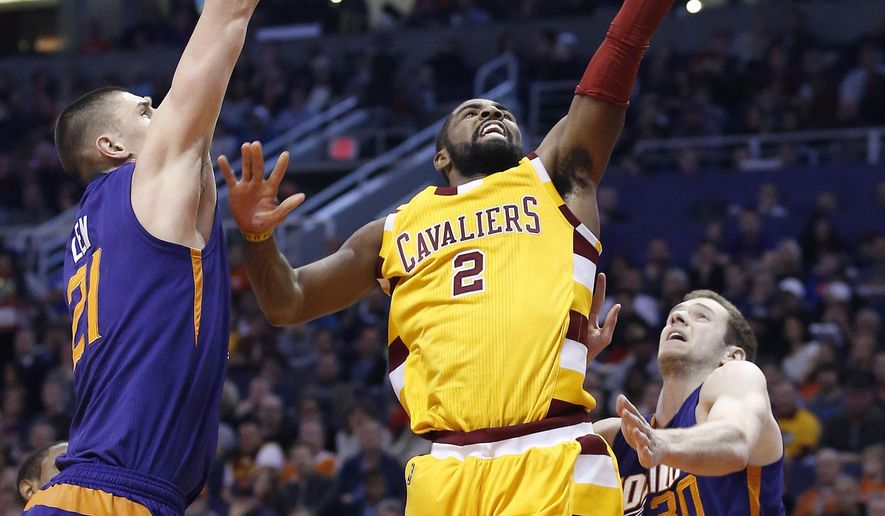 Cleveland Cavaliers&#39; Kyrie Irving (2) drives past Phoenix Suns&#39; Jon Leuer (30) and Alex Len (21), of Ukraine, to score during the first half of an NBA basketball game Monday, Dec. 28, 2015, in Phoenix. (AP Photo/Ross D. Franklin)