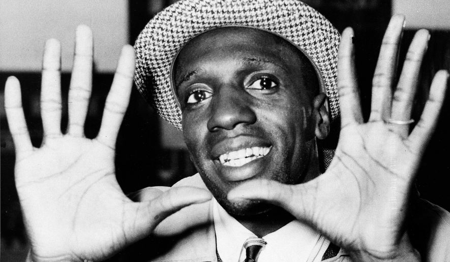 FILE - In this May 17, 1959, file photo, Meadowlark Lemon, of the Harlem Globetrotters, shows off his large hands on arrival in London where the team was to perform at the Empire Pool in Wembley for a week. Lemon, known as the Globetrotters' "clown prince" of basketball, died Sunday, Dec. 27, 2015, in Scottsdale, Ariz. He was 83. (AP Photo/File)