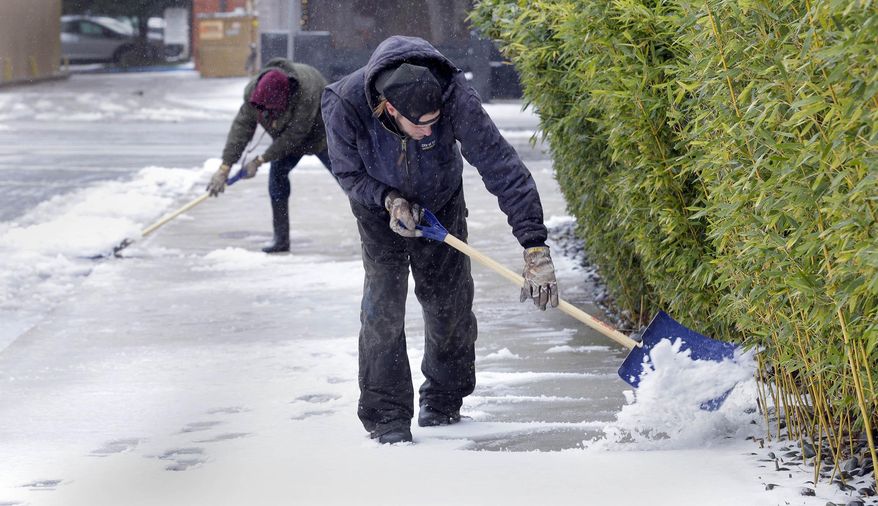 Mike walks home after going to the store in Tulsa, Okla., Monday, Dec. 28, 2015. A powerful winter storm pummeled Oklahoma with ice and flooding, leaving more than 50 people injured Monday, knocking out power to nearly 200,000 customers and snarling traffic on roads and at airports. (Mike Wyke/Tulsa World via AP)
