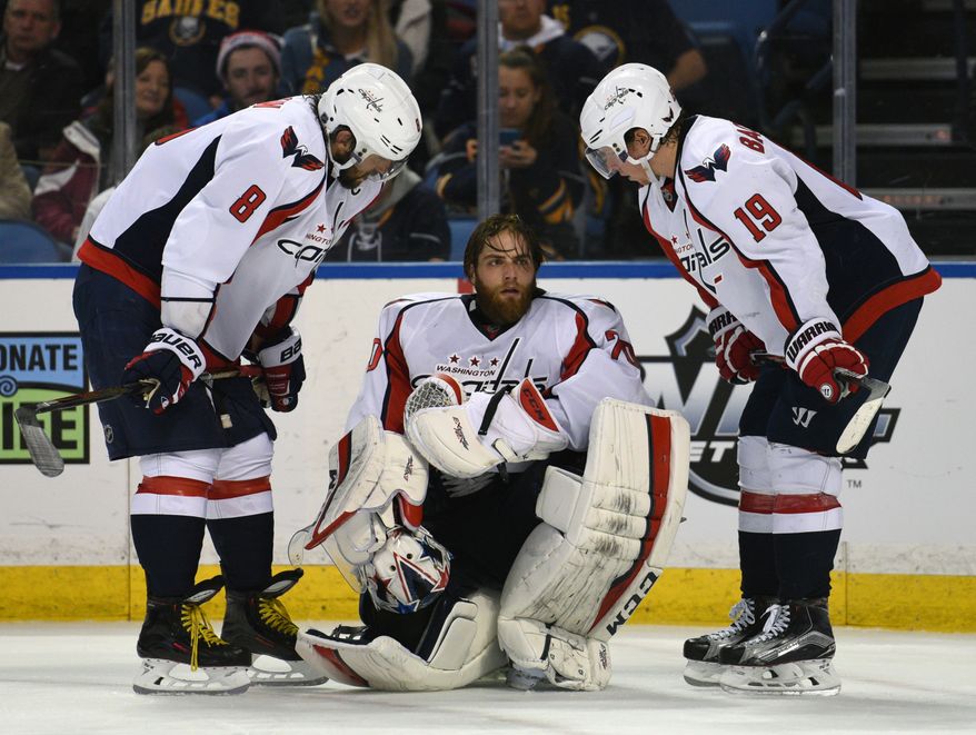 Washington Capitals left winger Alex Ovechkin (8), of Russia, and center Nicklas Backstrom (19), of Sweden, check on goaltender Braden Holtby (70) after a collision during the third period of an NHL hockey game against the Buffalo Sabres, Monday Dec. 28, 2015 in Buffalo, N.Y. Washington won 2-0. (AP Photo/Gary Wiepert)