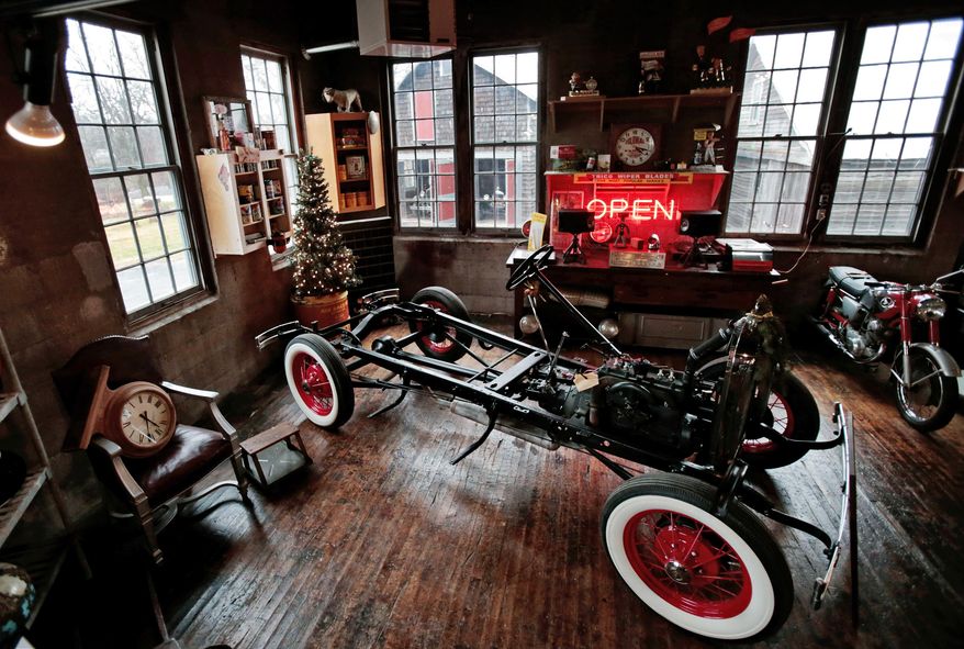 ADVANCE FOR SATURDAY, JAN. 2, 2016- In this photo taken on Tuesday, Dec. 22, 2015, a vintage car frame and other items are displayed at Badger Motor Car Company, a bar and museum in Columbus, Wis. One of the unique draws to the Badger Motor Car Co. is the workshop in the middle of the museum. Visitors can watch as Darvin Frey works on his 1930 Model A pickup truck. (M.P. King /Wisconsin State Journal via AP) MANDATORY CREDIT
