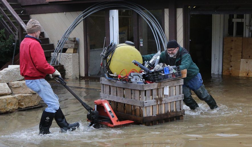 Mark Diehl, left, and Dale Atchley move items to higher ground at the Fenton Feed Mill on Tuesday, Dec. 29, 2015, in Fenton, Mo. Torrential rains over the past several days pushed already swollen rivers and streams to virtually unheard-of heights in parts of Missouri and Illinois. (J.B. Forbes /St. Louis Post-Dispatch via AP)  EDWARDSVILLE INTELLIGENCER OUT; THE ALTON TELEGRAPH OUT; MANDATORY CREDIT