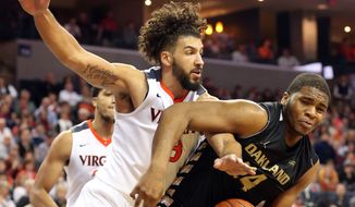 Virginia forward Anthony Gill (13) goes after the ball with Oakland center Percy Gibson, right, during an NCAA basketball game Wednesday, Dec. 30, 2015, in Charlottesville, Va. (AP Photo/Andrew Shurtleff)