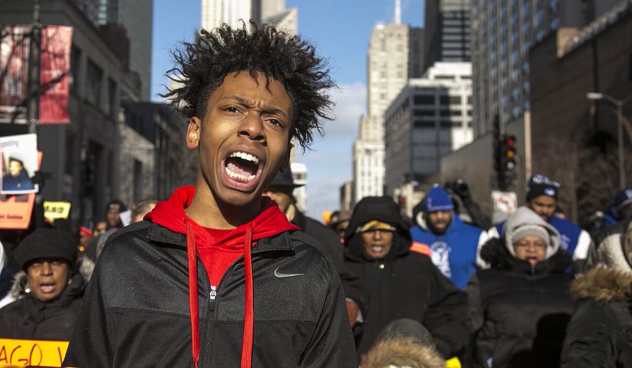 Community activist Lamon Reccord protests with Father Michael Pfleger and the Rev. Jesse Jackson in Chicago Dec. 31, 2015, against gun violence in the city. Activists are keeping up the pressure on Mayor Rahm Emanuel over fatal shootings by police and gun violence in the city. (Ashlee Rezin/Chicago Sun-Times via AP) **FILE**