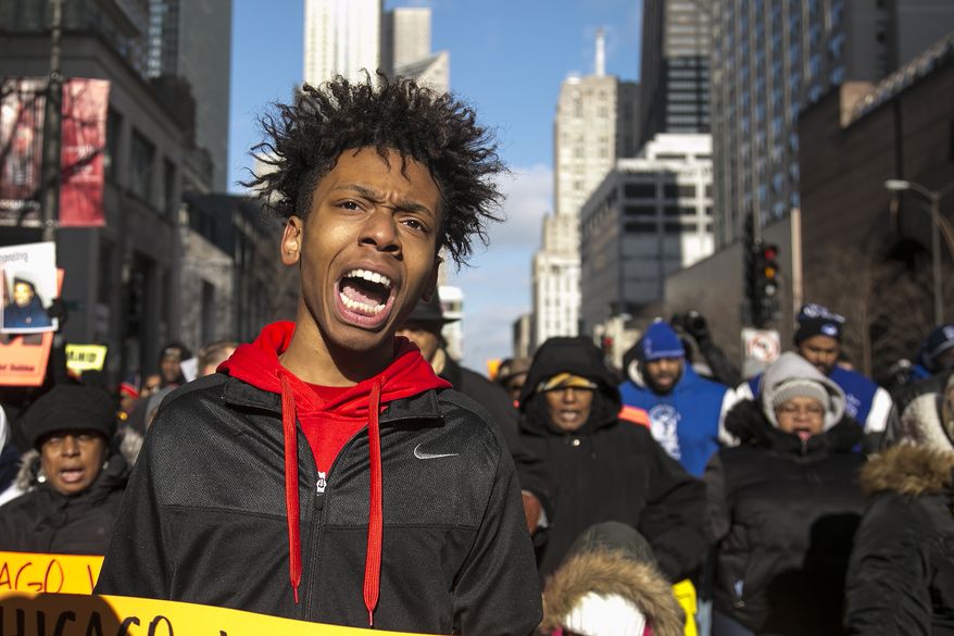 Community activist Lamon Reccord protests with Father Michael Pfleger and the Rev. Jesse Jackson in Chicago Dec. 31, 2015, against gun violence in the city. Activists are keeping up the pressure on Mayor Rahm Emanuel over fatal shootings by police and gun violence in the city. (Ashlee Rezin/Chicago Sun-Times via AP) **FILE**