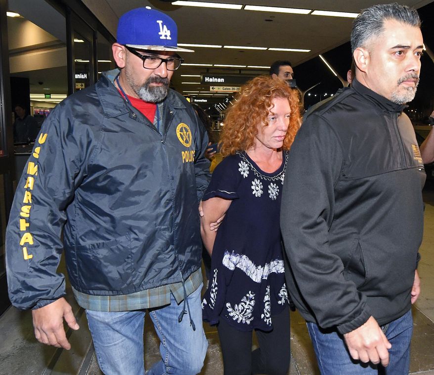 Tonya Couch, center, is taken by authorities to a waiting car after arriving at Los Angeles International Airport, Thursday, Dec. 31, 2015, in Los Angeles. Authorities said she and her son, Texas teenager Ethan Couch, who was sentenced to probation after using an "affluenza" defense for a 2013 wreck in Texas, fled to Mexico together in November as prosecutors investigated whether he had violated his probation. Both were taken into custody Monday, Dec. 28, after authorities said a phone call for pizza led to their capture in the resort city of Puerto Vallarta. (AP Photo/Mark J. Terrill)