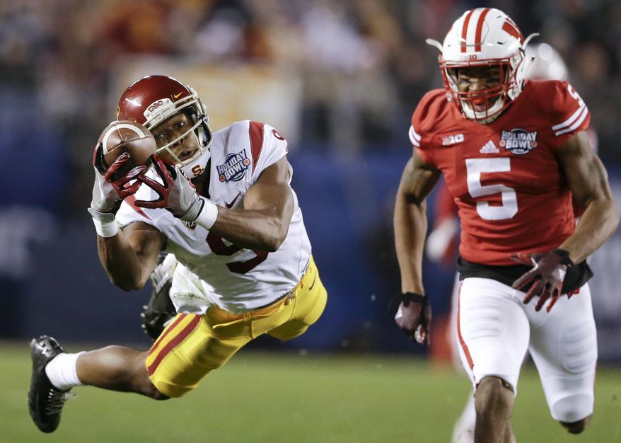 Southern California wide receiver JuJu Smith-Schuster (9) drops a pass as Wisconsin cornerback Darius Hillary (5) defends during the first half of the Holiday Bowl NCAA college football game Wednesday, Dec. 30, 2015, in San Diego. (AP Photo/Gregory Bull)