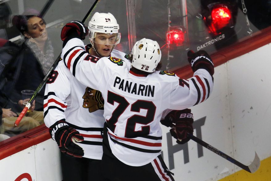 Chicago Blackhawks center Jonathan Toews, left, celebrates after scoring the winning goal with left wing Artemi Panarin, of Russia, against the Colorado Avalanche in overtime of an NHL hockey game Thursday, Dec. 31, 2015, in Denver. Chicago won 4-3. (AP Photo/David Zalubowski)
