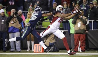 FILE- In this Nov. 15, 2015, file photo, Arizona Cardinals wide receiver Michael Floyd catches a pass for a touchdown as Seattle Seahawks cornerback Cary Williams defends during the first half of an NFL football game in Seattle. On a Sunday night seven weeks ago, th Cardinals pulled off a 39-32 victory over the Seahawks. They haven’t lost since. Now both teams are firmly in the playoffs, with seeding all that’s at stake when they meet in their regular-season finale on Sunday. (AP Photo/Elaine Thompson, File)