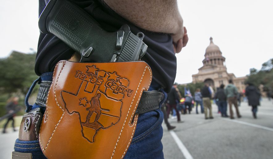 Terry Holcomb,executive director of Texas Carry, happily displays his customized holster as he walks to the Capitol for a rally, Friday, Jan. 1, 2016, in Austin, Texas. (Ralph Barrera /Austin American-Statesman via AP)  AUSTIN CHRONICLE OUT, COMMUNITY IMPACT OUT, INTERNET AND TV MUST CREDIT PHOTOGRAPHER AND STATESMAN.COM, MAGS OUT; MANDATORY CREDIT
