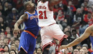 Chicago Bulls guard Jimmy Butler (21) drives the lane past New York Knicks center Kevin Seraphin (1) during the first half of an NBA basketball game in Chicago, on Friday, Jan. 1, 2016. (AP Photo/Jeff Haynes)