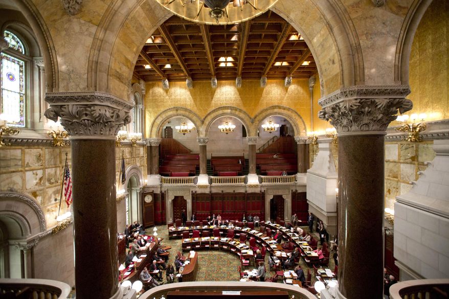 FILE - In this June 17, 2015, file photo, senators work in the Senate Chamber at the Capitol on the last scheduled day of the 2015 legislative session in Albany, N.Y. New York lawmakers returning to Albany during the first week of January 2016 face a long list of challenges as they seek to move past a disastrous 2015. (AP Photo/Mike Groll, File)