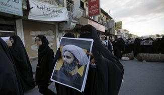 A Bahraini protester holds a picture of Saudi Shiite cleric Sheikh Nimr al-Nimr during a rally denouncing his execution by Saudi Arabia, Sunday, Jan. 3, 2016, in Daih, Bahrain. Saudi Arabia announced the execution of al-Nimr on Saturday along with 46 others. Al-Nimr was a central figure in protests by Saudi Arabia&#39;s Shiite minority until his arrest in 2012, and his execution drew condemnation from Shiites across the region. (AP Photo/Hasan Jamali)