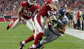 Seattle Seahawks wide receiver Jermaine Kearse (15) falls into the end zone for a touchdown as Arizona Cardinals free safety Rashad Johnson (26) and cornerback Justin Bethel (28) defend during the first half of an NFL football game, Sunday, Jan. 3, 2016, in Glendale, Ariz. (AP Photo/Ross D. Franklin)
