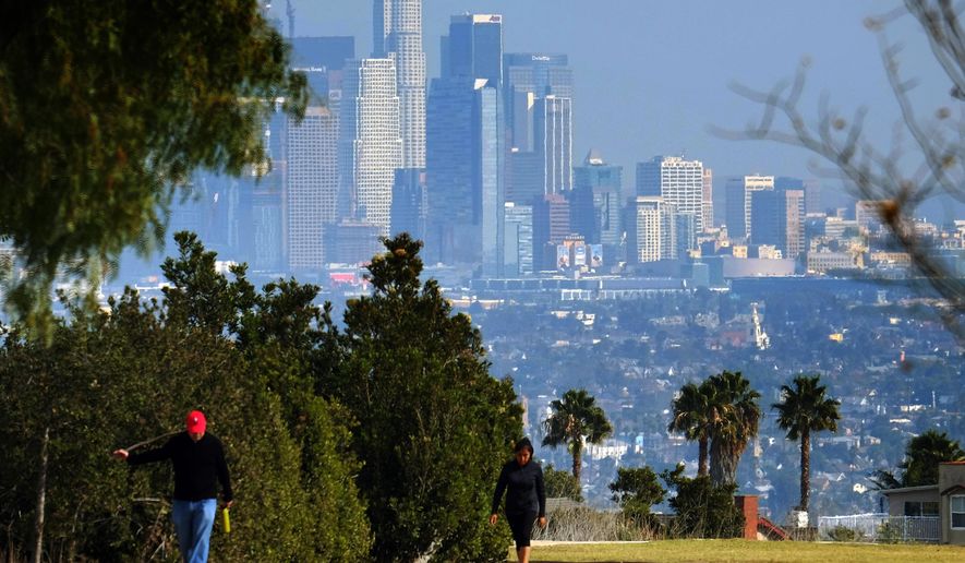 Hikers walk along a path at the Kenneth Hahn State Recreation Area near downtown Los Angeles on Sunday, Jan. 3, 2016. Southern California is bracing for a series of storms expected to begin late Sunday that could last all week. (AP Photo/Richard Vogel)