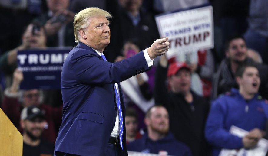 Republican presidential candidate Donald Trump gestures as a protestor is removed from the arena during a campaign stop at the Tsongas Center in Lowell, Mass., Monday, Jan. 4, 2016. (AP Photo/Charles Krupa)
