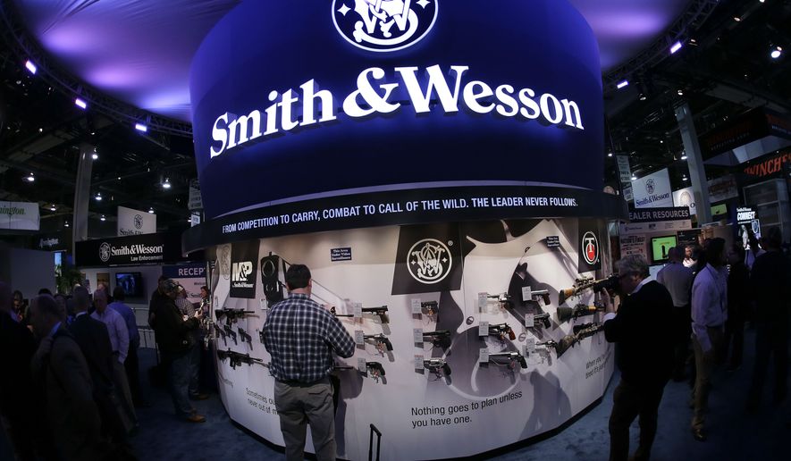 In this Tuesday, Jan. 14, 2014, file photo, trade show attendees examine handguns and rifles in the Smith &amp; Wesson display boot at the Shooting Hunting and Outdoor Tradeshow, in Las Vegas. With all major markets in a severe sell-off Monday, Jan. 4, 2016, shares of companies that make guns surged as new data pointed to strong sales at the close of 2015, a year marked by mass shootings in Paris and California, and new political pressure to tighten regulations. Shares of Smith &amp; Wesson Holding Corp. rose almost 6 percent Monday, one of the biggest percentage gains over the past year for the gunmaker. Its shares hit an all-time high two weeks earlier. (AP Photo/Julie Jacobson, File)