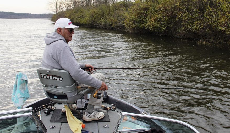 In this Dec. 10, 2015 photo, Dave Henson uses a two-handed approach to catching crappie on Crab Orchard Lake near Carterville, Ill. Although many anglers have mothballed their rods and reels for the season, Henson continues to mine for Crab Orchard crappie on a regular basis. (Les Winkeler/The Southern via AP) MANDATORY CREDIT