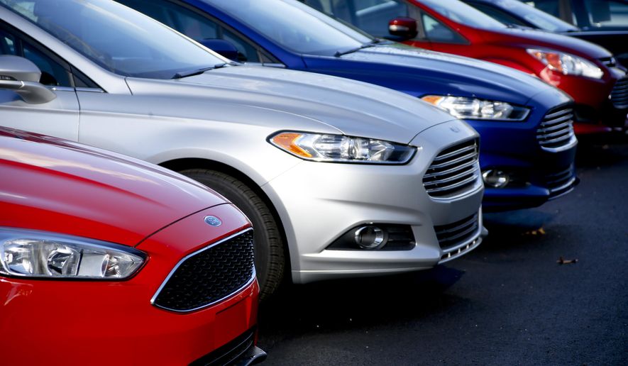 This Thursday, Nov. 19, 2015, photo, shows a row of new 2015 Ford Fusions on the sales lot at Butler County Ford in Butler, Pa. Automakers report December and full-year sales Tuesday, Jan. 5, 2016. (AP Photo/Keith Srakocic)