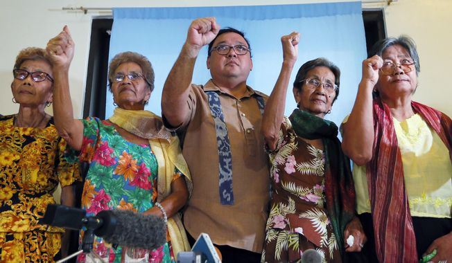 Four of the remaining 32 alleged WWII sex slaves clench their fists along with their legal counsel Harry Roque, center, to demand compensation and apology from the Japanese Government during a news conference in Manila, Philippines, Wednesday, Jan. 6, 2016. The announcement Wednesday came following a landmark agreement between South Korea and Japan recently of an “irreversible” settlement of a decades-long standoff over Korean women forced into sexual slavery by Japan’s WWII military. They are, from left, Avelina Culala, 85, Isabelita Vinuya, 84, Emilia Mangilit, 83, Isabelita Vinuya, 84 and Candelaria Soliman, 85. (AP Photo/Bullit Marquez)