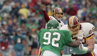 Washington Redskins Mark Rypien passes under pressure from Philadelphia Eagles Reggie White during first quarter action in Wildcard playoff game, Saturday, Jan. 5, 1991 at Philadelphia Veterans Stadium. Holding off White is Redskins Joe Jacoby. Rypien threw two touchdown passes the lead the Redskins to a 20-6 upset win. (AP Photo/Amy Sancetta) **FILE**