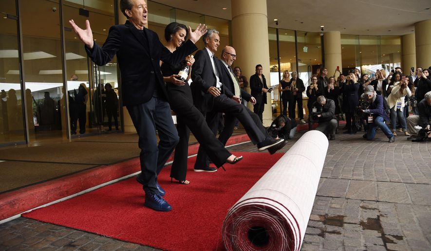 Golden Globes executive producer Barry Adelman, from left, Miss Golden Globe 2016 Corinne Foxx, executive producer Allen Shapiro and Lorenzo Soria, president of the Hollywood Foreign Press Association, roll out the red carpet during the 73rd Annual Golden Globe Awards Preview Day at the Beverly Hilton on Thursday, Jan. 7, 2016, in Beverly Hills, Calif. The annual awards show including film and television will be held on Sunday. (Photo by Chris Pizzello/Invision/AP)