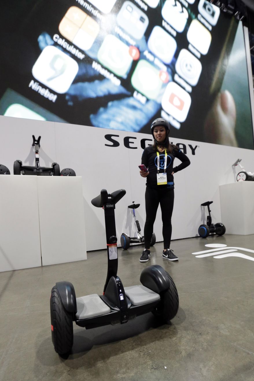 Mika Ascalson controls a Segway MiniPRO with a phone app at CES International, Wednesday, Jan. 6, 2016, in Las Vegas. (AP Photo/Gregory Bull)