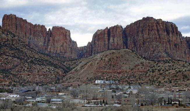 This Dec. 16, 2014, file photo shows Hildale, Utah, sitting at the base of Red Rock Cliff mountains, with its sister city, Colorado City, Ariz., in the foreground. A trial that begins January 2016 in Phoenix is expected to reveal the inner workings of two secluded towns on the Arizona-Utah line that authorities say were acting as agents of a corrupt polygamist regime. (AP Photo/Rick Bowmer/ File)