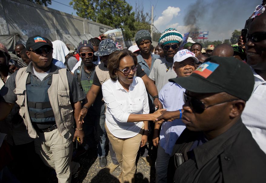 Presidential candidate Maryse Narcisse, center, greets supporters during a protest against the government in Port-au-Prince, Haiti, Friday, Jan. 8, 2016. Campaigning for Haiti's presidential runoff has kicked off, but it appears there's only one candidate actively participating. Government-backed contender Jovenel Moise was scheduled to hold his first runoff rally late Friday. But No. 2 candidate Jude Celestin's team says he will only take part in the vote if sweeping changes are made to electoral machinery. (AP Photo/Dieu Nalio Chery)