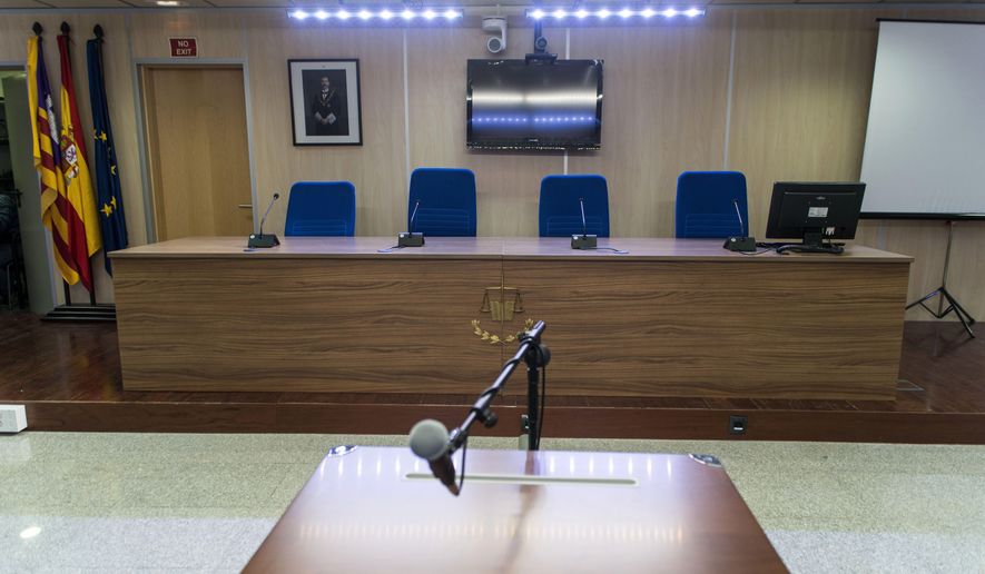 In an empty courtroom, a photo of Spain's King Felipe VI, top left, hangs behind where the judges will sit, in Palma de Mallorca, Spain, Thursday Jan. 7, 2016. Spain’s Princess Cristina will stand trial on tax fraud charges on Jan. 11, 2016. Cristina, sister of King Felipe VI, was indicted as part of a four-year probe into her husband, Inaki Urdangarin, who faces charges of money-laundering and fraud. The 50-year-old princess and her husband are set to face anti-monarchy protesters and hordes of media as they enter a makeshift courtroom and she makes history on live TV to millions of Spaniards by becoming the first royal family member to face criminal charges since the monarchy was restored in 1975. (Cati Cladera, Pool Photo via AP)
