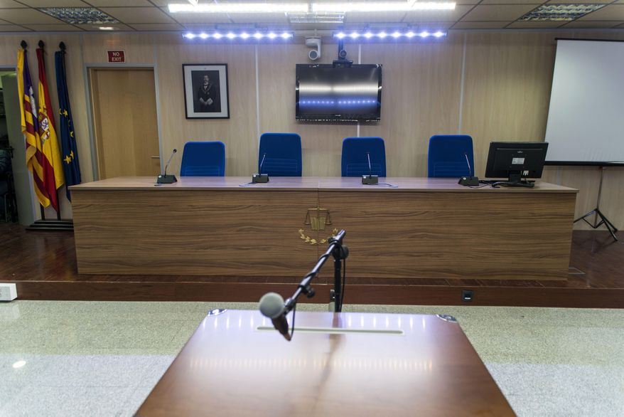 In an empty courtroom, a photo of Spain's King Felipe VI, top left, hangs behind where the judges will sit, in Palma de Mallorca, Spain, Thursday Jan. 7, 2016. Spain’s Princess Cristina will stand trial on tax fraud charges on Jan. 11, 2016. Cristina, sister of King Felipe VI, was indicted as part of a four-year probe into her husband, Inaki Urdangarin, who faces charges of money-laundering and fraud. The 50-year-old princess and her husband are set to face anti-monarchy protesters and hordes of media as they enter a makeshift courtroom and she makes history on live TV to millions of Spaniards by becoming the first royal family member to face criminal charges since the monarchy was restored in 1975. (Cati Cladera, Pool Photo via AP)