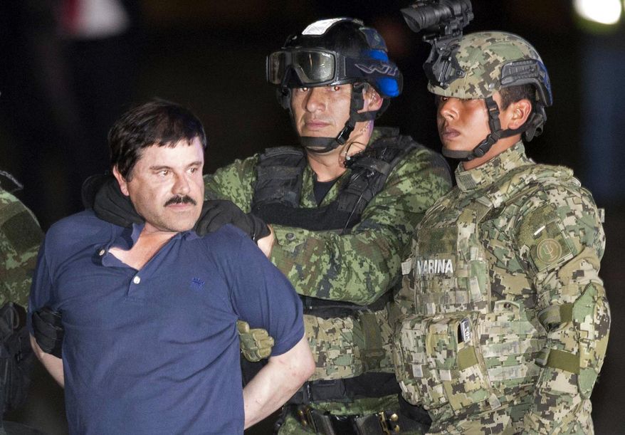 In this Friday, Jan. 8, 2016 photo, Joaquin "El Chapo" Guzman is made to face the press as he's escorted to a helicopter in handcuffs by soldiers and marines at a federal hangar in Mexico City. Guzman's second prison escape in 2015 from a top security prison though a tunnel had embarrassed President Enrique Pena Nieto and made his capture a national priority. (AP Photo/Eduardo Verdugo)