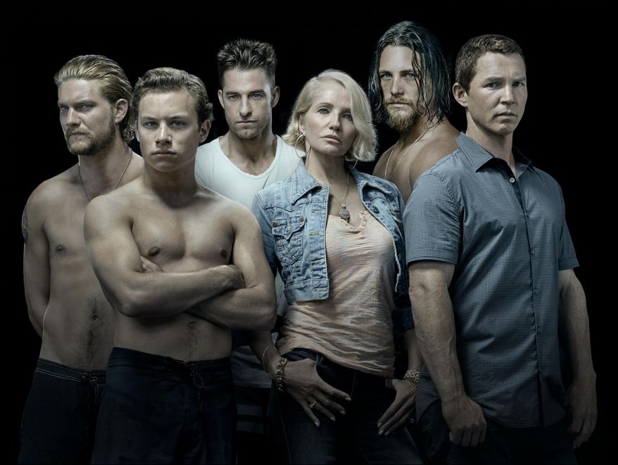 This image released by TNT shows the cast of the new series "Animal Kingdom," starring Ellen Barkin, from row center, as the matriarch of a crime family. Kevin Reilly has begun the process of transforming the Turner Networks of TBS and TNT from a home for television comfort food into what he hopes is a destination for buzzy, edgy fare that can compete on the same turf as the AMC, Netflix and HBOs of the world. (Michael Muller/TNT via AP)