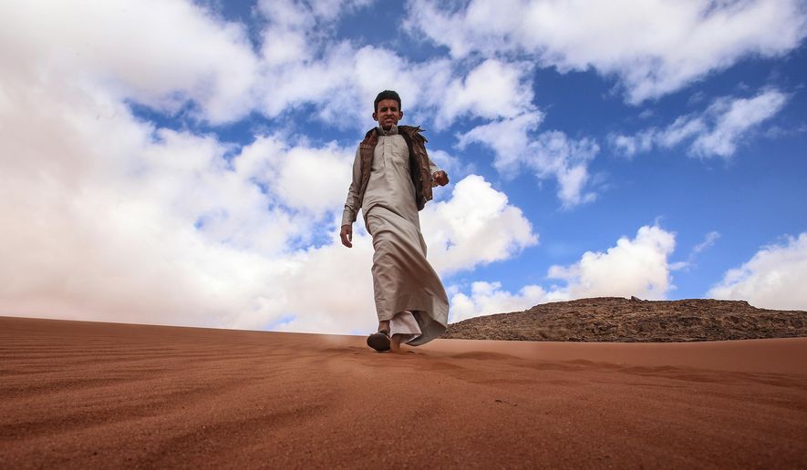 In this Saturday, Jan. 9, 2016 photo, Jacir Eid Al-Hwietat, 15, poses for a photo in Wadi Rum, a scenic desert area of southern Jordan. Jacir and his cousin, both from a Bedouin clan, acted in the film "Theeb" (Wolf), a coming-of-age drama set in 1916, that has emerged as the first Oscar contender of Jordan’s nascent film industry. The final five will be announced Thursday. (AP Photo/ Raad Adayleh)